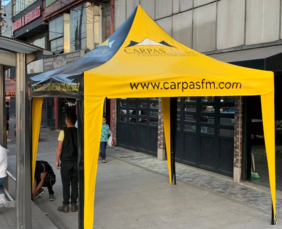 Carpa Tipo Kiosco de la empresa Carpas FM de color amarillo y negro en una calle de Bogotá, Colombia