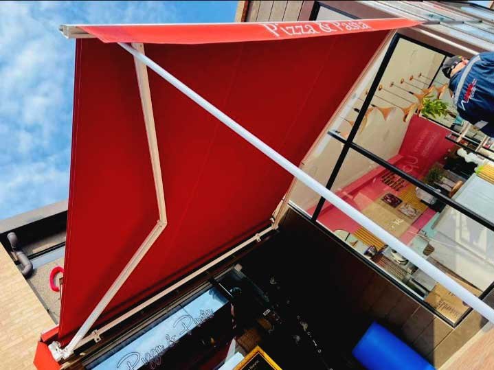 Vemos un toldo plegable de color rojo.